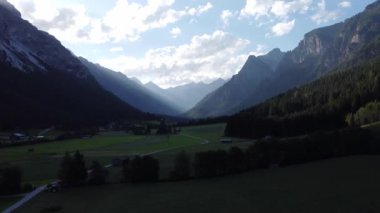 Avusturya 'daki dağlar, Brenner Geçidi' nde alacakaranlıkta çayır ve ormanlarla birlikte 4K 'da.