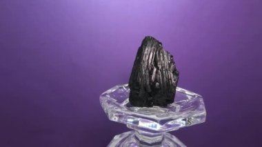 Aynalı bir taşın soyut, çarpıtılmış ve büyülü hareketleri sanatsal bir arka plan olarak gösterilir.