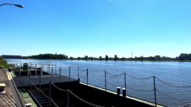 Mavi gökyüzü ve suyla Danube nehrindeki büyük gemiler için paslı iskele