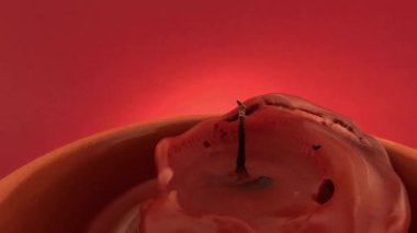 Kırmızı arkaplanda yanan kırmızı mum dumanla söndürüldü, 4k