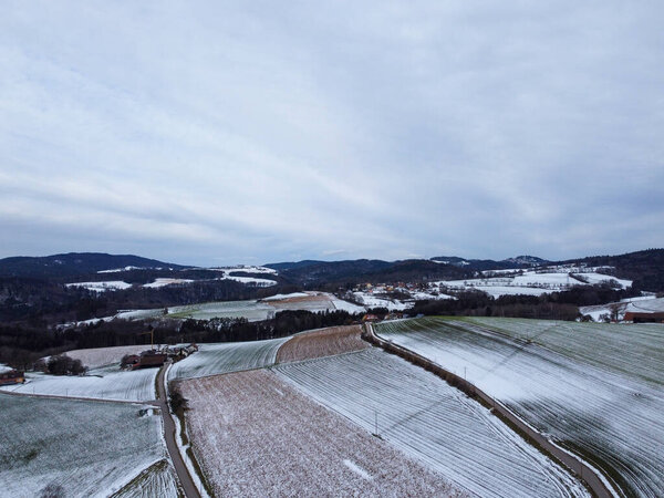 snow-covered agricultural fields in bavaria on a cloudy day