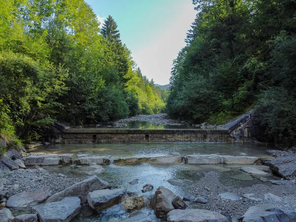 Yukarı Bavyera 'da, güneş doğarken baraj ve büyük taşlarla dolu doğal bir bölgede akarsu, 4k