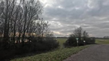 Bulutlu bir gökyüzünün altında taşra yolunda araba yolculuğu