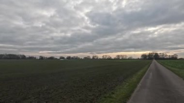 Bulutlu bir gökyüzünün altında taşra yolunda araba yolculuğu