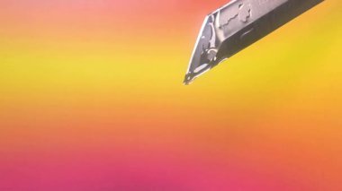 Sarı arka planda bıçaktan damlayan damlalar.