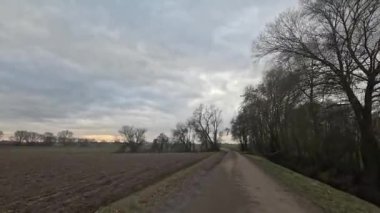 Araba ufukta geziniyor. Tarlalar, çayırlar ve bulutlar arasında.