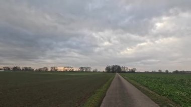 Araba ufukta geziniyor. Tarlalar, çayırlar ve bulutlar arasında.