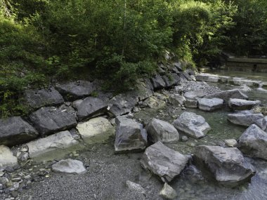 Yukarı Bavyera 'da, güneş doğarken baraj ve büyük taşlarla dolu doğal bir bölgede akarsu, 4k