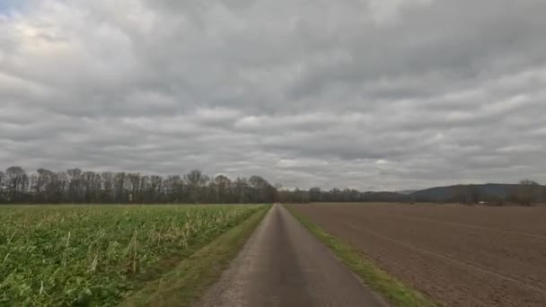 驾车驶向地平线 穿过田野 草地和云朵 — 图库视频影像