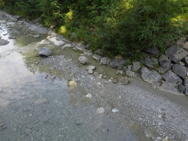 Yukarı Bavyera 'da, güneş doğarken baraj ve büyük taşlarla dolu doğal bir bölgede akarsu, 4k
