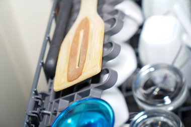 Bulaşık makinesi, yeni yıkanmış tabaklar, bardaklar ve çatal bıçak takımı, ev eşyaları.