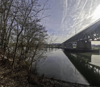 Güneş ışığı ve bulutlu Regensburg yakınlarında köprüsü olan Tuna Nehri