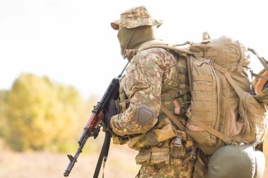 Askeri üniformalı Ukraynalı asker ve savaş alanında tam teçhizat.