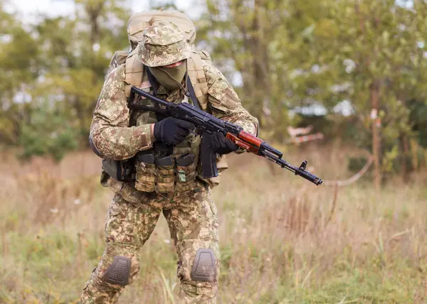 Ukrainian soldier in military uniform and full equipment on the battlefield in the war
