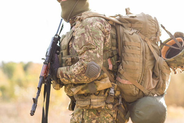 Украинский солдат в военной форме и полной экипировке на поле боя в войне