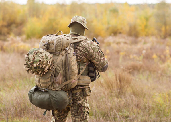 Украинский солдат в военной форме и полной экипировке на поле боя в войне
