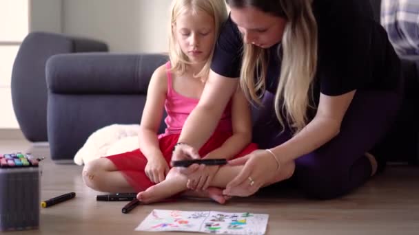 母親と一緒にいる小さな女の子は 家でコミュニケーションをとり 描いています — ストック動画