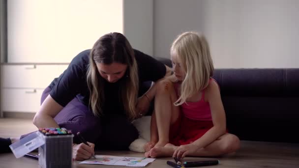 母親と一緒にいる小さな女の子は 家でコミュニケーションをとり 描いています — ストック動画