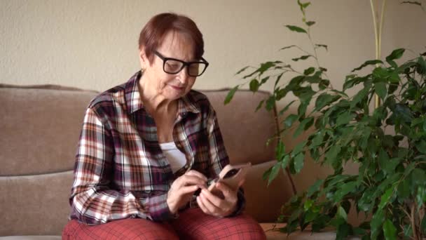 一位八十岁的妇女坐在电话旁 在家工作 与电话亲密的手 — 图库视频影像