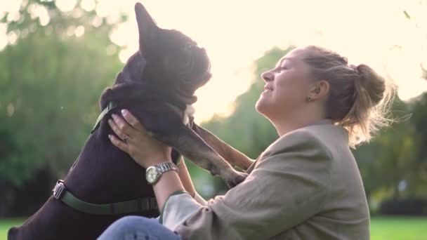 パーク4K映像の草の上に彼女の犬 フランスのブルドッグと遊ぶ彼女の前菜の女性 — ストック動画