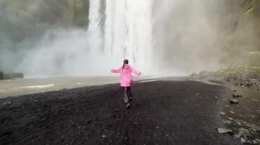 İzlanda 'da bir kız soğuk bir şelaleye daldı. 4K görüntüler.