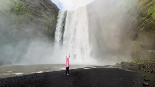 冰岛一个女孩站在瀑布边 陷入沉思状态 有4K个镜头 — 图库视频影像