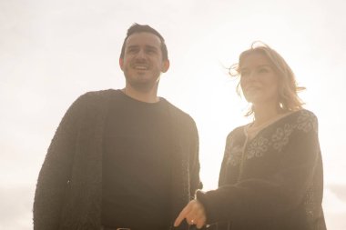 Dağın arka planına ve sonbaharda dağlarda batan güneşe karşı aşık bir çift.