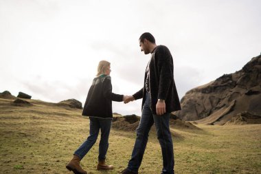 Dağın arka planına ve sonbaharda dağlarda batan güneşe karşı aşık bir çift.