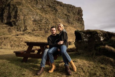 Dağın arka planına ve sonbaharda dağlarda batan güneşe karşı aşık bir çift.