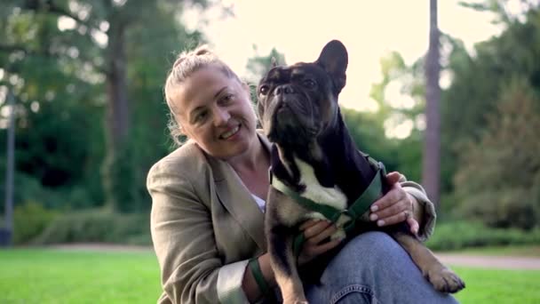 Seorang Wanita Berusia Bermain Dengan Anjingnya Seekor Bulldog Prancis Rumput — Stok Video
