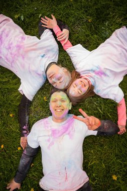 Holi 'yi pudra rengi veya gulal ile kutlayan Avrupalı mutlu bir aile. Hint festivali Holi kavramı.