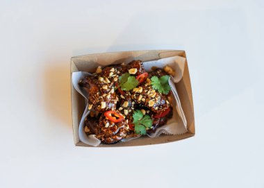 Baharatlı ızgara tavuk teriyaki bacakları teslimat için paketlerde..