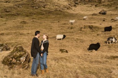 Dağın arka planına ve sonbaharda dağlarda batan güneşe karşı aşık bir çift.