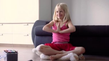 Küçük kız evde öğretmeniyle yoga öğreniyor.