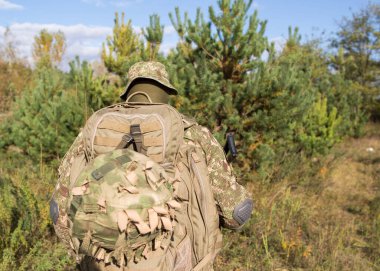 Askeri üniformalı Ukraynalı asker ve savaş alanında tam teçhizat.