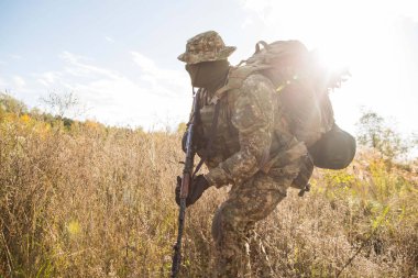 Askeri üniformalı Ukraynalı asker ve savaş alanında tam teçhizat.