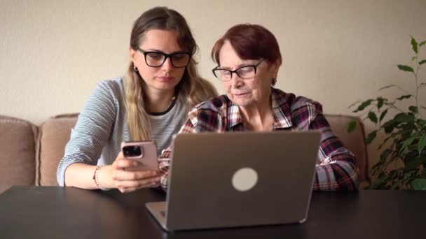 孙女告诉她的老祖母如何使用笔记本电脑 教奶奶如何使用电脑 — 图库视频影像