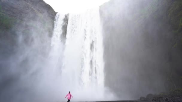 Ένα Κορίτσι Στέκεται Έναν Καταρράκτη Στην Ισλανδία Κατάσταση Διαλογισμού Πλάνα — Αρχείο Βίντεο