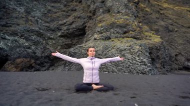 İzlanda 'da Vik' in siyah plajında yoga yapan kız.