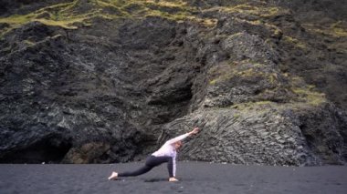 İzlanda 'da Vik' in siyah plajında yoga yapan kız.