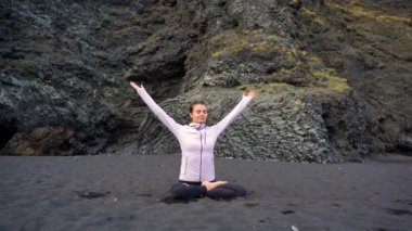 İzlanda 'da Vik' in siyah plajında yoga yapan kız.