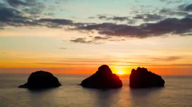 İzlanda 'da gün batımında dağlarda 3 küçük ada, insansız hava aracı manzaralı.