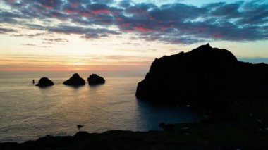 İzlanda 'da gün batımında dağlarda 3 küçük ada, insansız hava aracı manzaralı.