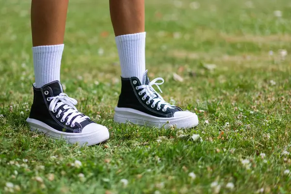时髦的黑色运动鞋 白色的膝盖袜 草色背景 — 图库照片