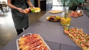 Etkinlikte, garson masaya bir tabak taze lezzetli yemek koyar. Masaya ve ellerine yakın çekim yap.