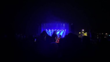 Mutlu insanlar inanılmaz bir müzik konseri izliyorlar. Neşeli hayranlar zıplıyor ve ellerini kaldırıyor. Heyecanlı hayranlar en sevdikleri şarkıyı söyleyen popüler grubu alkışlıyorlar. Telefonları olan bir grup hayran.