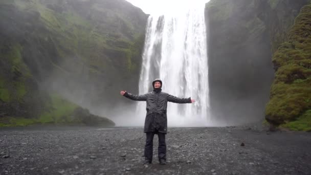 Guy Mot Bakgrund Ett Vattenfall Island Regnet — Stockvideo