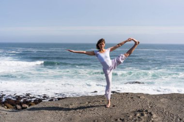 Bir kız İzlanda 'da okyanusta yoga yapıyor.