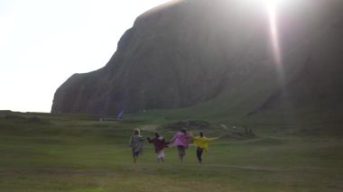 Renkli yağmurluklu bir grup turist İzlanda 'daki dağların arka planına karşı.