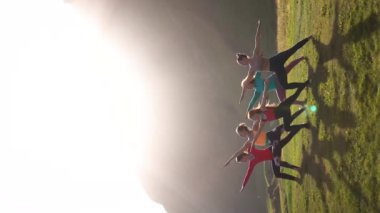 İzlanda dağlarında gün batımında yoga yapan bir grup kız.